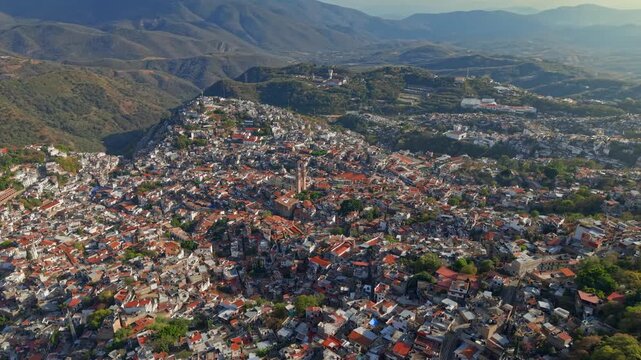 Aerial view of Taxco de Alarcon, Guerrero, Mexico on a sunny day with the mountains in the background, colonial architecture with white houses and tiled roofs.