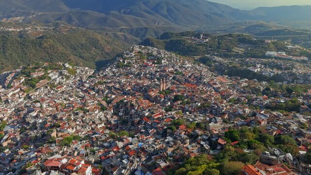 Aerial panoramic view of the city of Taxco de Alarcon on a sunny day, with colonial architecture and tiled roofs, in the state of Guerrero, Mexico.