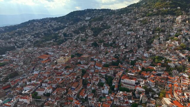Panoramic aerial view revealing the town of Taxco de Alarcon in Guerrero, Mexico, with the entire town built on three mountains in the Sierra, high frame rate.