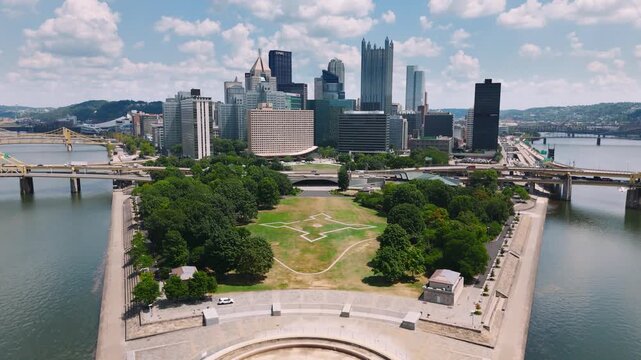 Wide drone shot of Pittsburgh skyline featuring rivers and urban architecture. Great for backgrounds or promotional media.