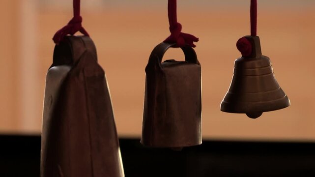 Three small rattles hanging in close-up with a blurred background.