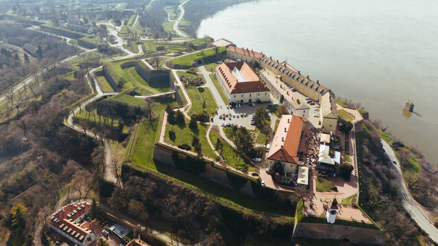 Aerial view of the formidable Petrovaradin Fortress standing tall, its red roofs contrasting against the green fortifications, overlooking the Danube River, Petrovaradin, Vojvodina, Serbia.