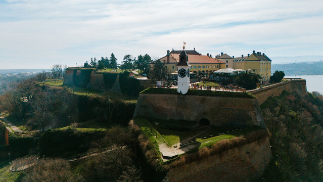 Aerial view of the Petrovaradin Fortress standing proudly with its clock tower and weathered stone walls, a silent sentinel overlooking the landscape, Petrovaradin, Vojvodina, Serbia.