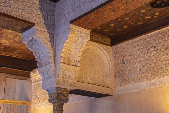 Primer plano de la intrincada decoraci&oacute;n de moc&aacute;rabes en arcos y yeser&iacute;as talladas con caligraf&iacute;a &aacute;rabe en los Palacios Nazar&iacute;es de la Alhambra, Granada, mostrando el arte isl&aacute;mico medieval.