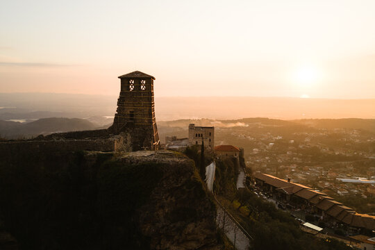 Aerial view of the ancient fortress walls and tower bathed in the warm glow of the setting sun, Kruje, Albania.