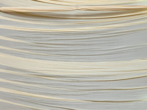 Close up of window sheer curtain fabric texture in beige cream color. Suitable for window or interior drapery decoration. For fashion, designer. Seamless background texture.