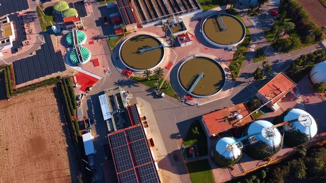 Sludge digesters and water clarifiers. Aerial view of dome shaped storage tanks and circular sedimentation basins at a modern treatment facility.