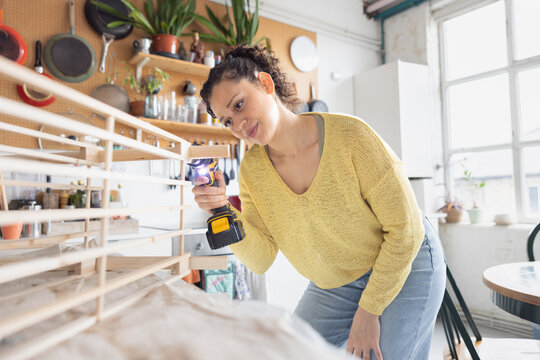 Young Woman Assembling a piece of flat pack furniture at home