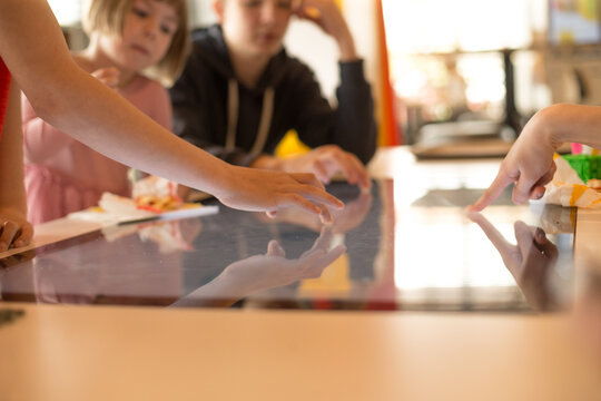 Children fingers touching an interactive touchscreen surface, exploring digital content through play and learning.