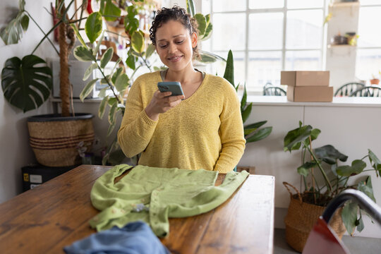 Young woman taking a photo to sell clothes online