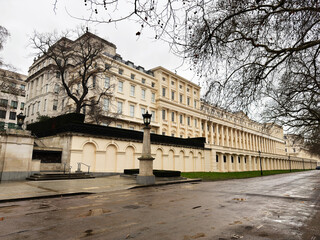Naklejka premium Historic white building with long colonnade Carlton House Terrace along a quiet London street in a refined urban setting