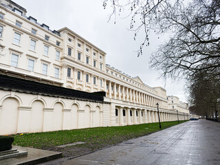 Naklejka premium London Carlton House Terrace architectural facade along a long cream building with arches and bare trees on a quiet street