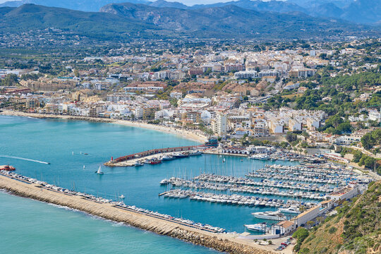 Panoramic view of coastal town and marina with mountains in Spain