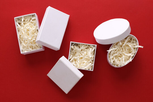 Mockup of a white cardboard boxes with filler on red background