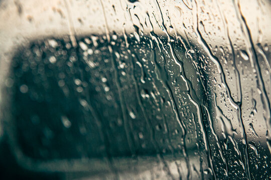 Vidro de Janela de carro com gotas e retrovisor em dia de chuva
