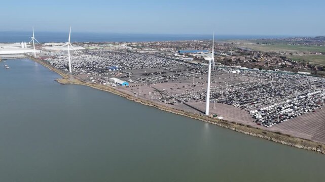 Row Wind Turbines with new car imports parked Sheppey Kent drone, aerial