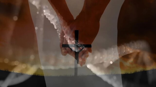 Hands holding cross against warm sunset colors with animated serene landscape