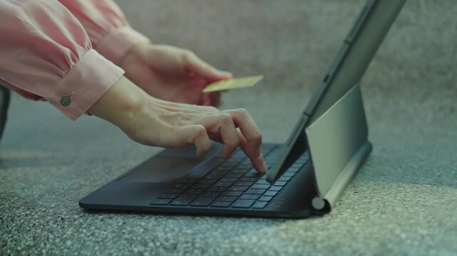 Close-up of a woman holding a credit card and smartphone, making an online payment or shopping on a mobile app, representing digital finance, e-commerce, and modern cashless transactions.