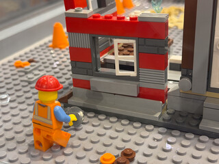 Naklejka premium Lego worker at a red-and-gray construction wall