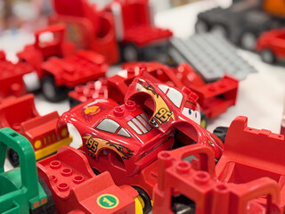 Naklejka premium Red toy race car among red building blocks