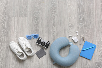 Traveler's accessories on light wooden floor, top view