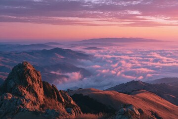 Naklejka premium Dawn over a mountaintop with rosy cloudscape and expansive sky