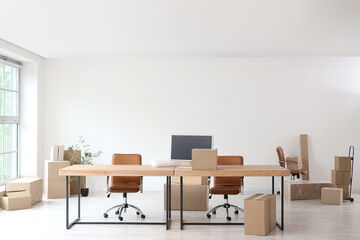 Fototapeta premium Workplace with chairs and cardboard boxes in office on moving day