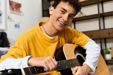 Obraz premium Stylish teenager enjoys playing guitar in a cozy home setting