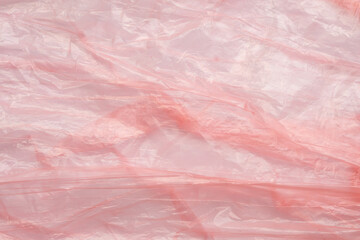 Fototapeta premium Crumpled red plastic texture, wrinkled polyethylene bag surface background