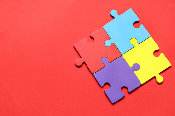 Colorful puzzle pieces on red background. Autistic disorder concept