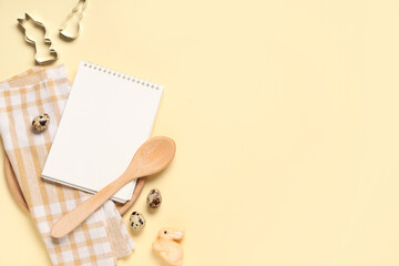 Obraz premium Composition with blank notebook for recipes, quail eggs, kitchen utensils and Easter bunny on color background