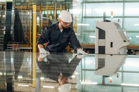 Process of preparing glass for windows. Warehouse worker in an industrial environment of a factory or storage area