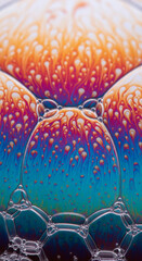 Fototapeta premium Close-up of iridescent bubble cluster with orange, red and blue colors creating abstract design, representing fragility, iridescence, fluidity and optical illusion