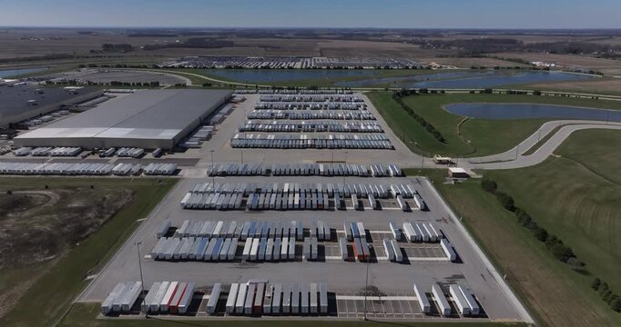 Aerial view of numerous parked trailers and a large building, exhibiting a blend of industrial activity and serene landscape, Greensburg, Indiana, United States.