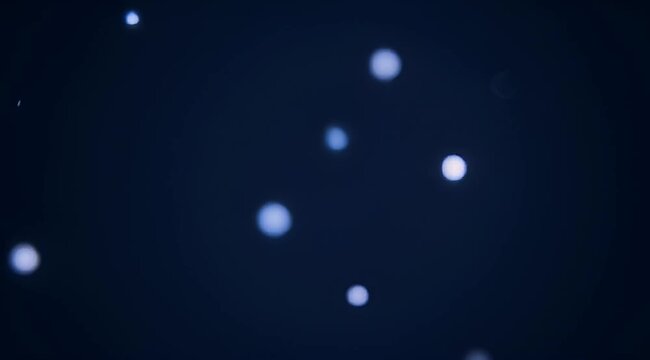 Mysterious deep blue bokeh background with ethereal light orbs scattered in space
