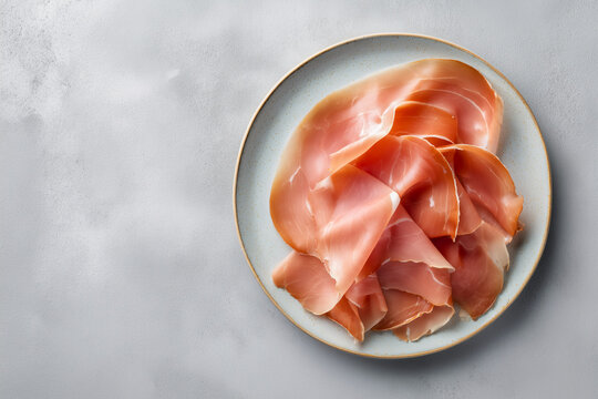 Sliced jamon serrano on a ceramic plate top view