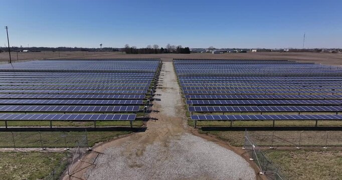 Aerial view of rows of solar panels creating a geometric blue pattern against the muted beige ground, Batesville, Indiana, United States.