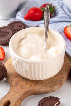 Liquid marshmallow fluff, sweet american dessert topping or dip, with strawberry and cookies for dipping in, copy space
