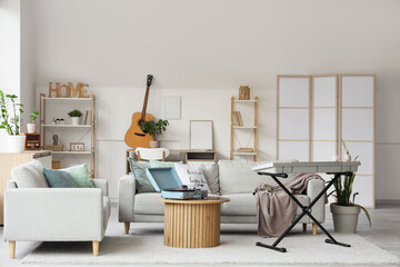 Fototapeta premium Interior of light living room with sofas, table and musical instruments