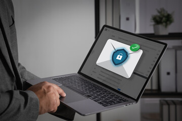 Laptop computer displaying a secure blue email notification icon on screen for digital marketing, highlighting professional business communication technology and a cool office workspace setup