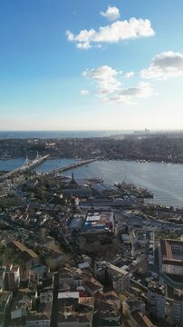 Aerial view of buildings and waterways under a bright sun, creating a dynamic composition of light and shadows, Istanbul, Turkey.