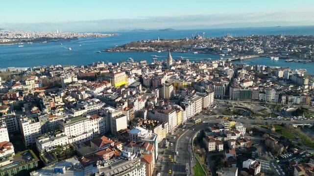 Aerial view of the Galata Tower amidst the sprawling cityscape with waterways and distant buildings under a clear sky, Istanbul, Turkey.