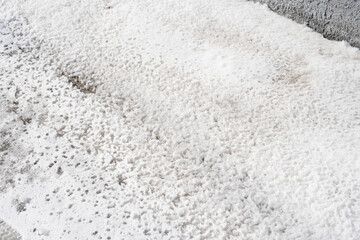 Snow-covered ground with scattered dirt patches in winter season  