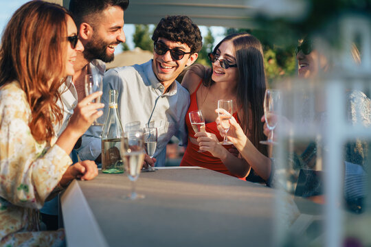Team celebrating achievement with champagne toast during rooftop evening event