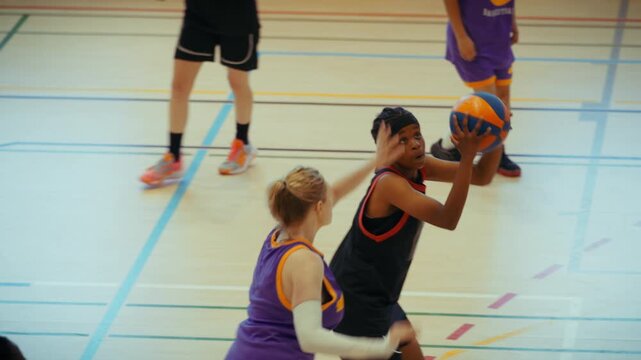 Young athletes playing basketball on court