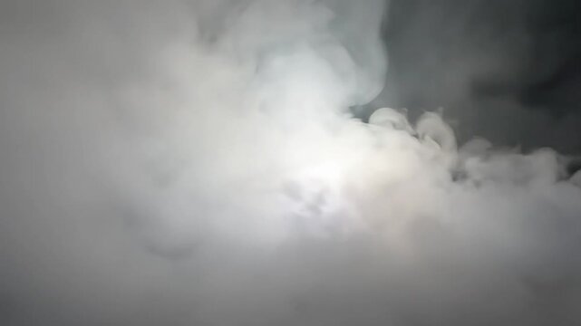 dramatic cloudy sky with sun peeking through thick white clouds