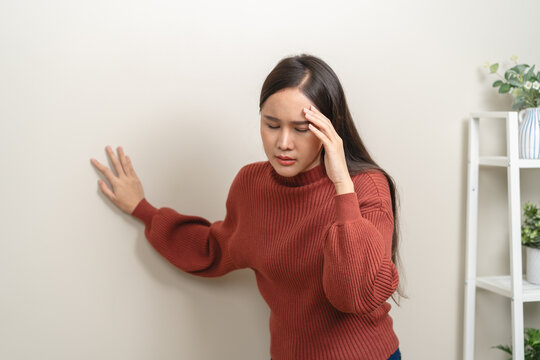 A woman is feeling dizzy and losing balance while standing.