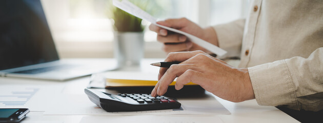 Deduction planning, debt asian accountant hand using calculator to calculating money balance from...