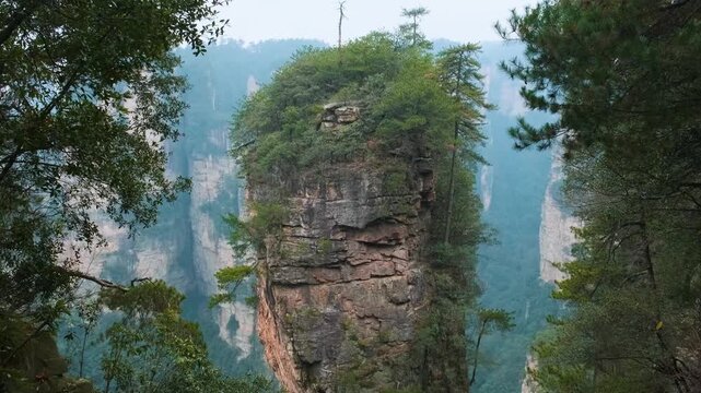 Vertical quartz sandstone rock pillars rising through mist in Yuanjiajie scenic area of Zhangjiajie National Forest Park landscape, Hunan, China. Travel and tourism landmark in Asia