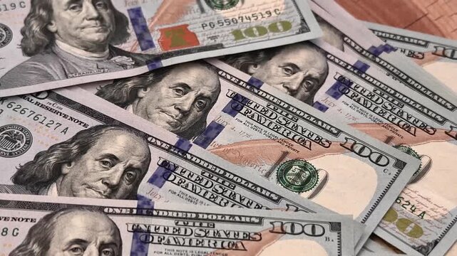 Luxury stack of US dollar bills on a prestigious solid oak table. Financial success, wealth and chic lifestyle concept. Cash money on expensive wood surface for premium business background.